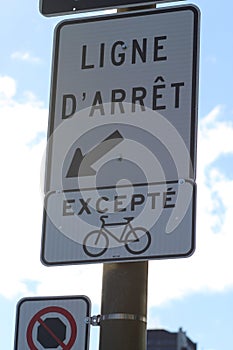 French street sign "STOP LINE" against cloudy blue sky