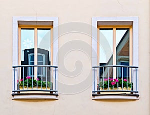 French style balcony windows with geranium flower pots