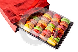 French sweets macaroons in a red gift bag with a bow. Selective focus