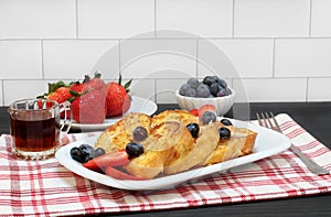 French toast with blueberries, strawberries and maple syrup
