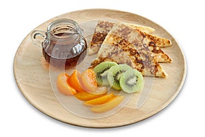 French toast and fresh fruit with honey on wooden plate for breakfast