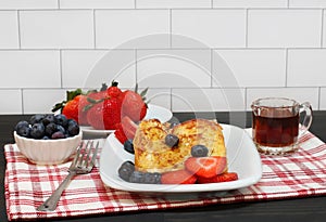 French toast with syrup,  fresh blueberries and strawberries