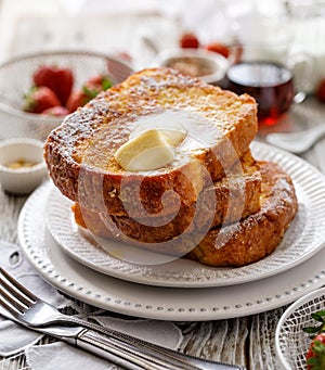 French toast, warm French toast made of sliced brioche with fresh butter, sprinkled with powdered sugar.