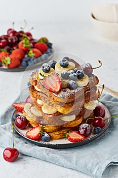 French toasts with berries and banana, brioche breakfast, white background, vertical closeup