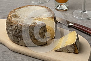 French Tommette de Montagne and a piece on a cutting board close up photo