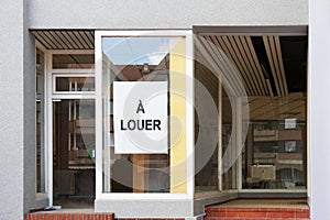 French vacancy sign in empty shop window reads a louer meaning for rent