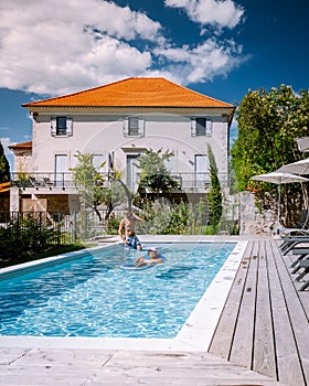 French vacation home with wooden deck and swimming pool in the Ardeche France. Couple relaxing by the pool with wooden