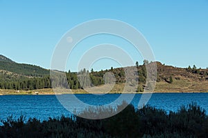 Frenchman lake at sunset land and water with full moon in the sky