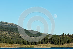 Frenchman lake at sunset land and water with full moon in the sky