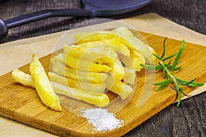 Frensh fries with rosemary on table