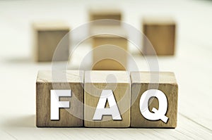 Frequently Asked Questions with wooden block. FAQ concept