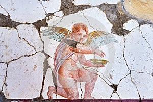 Fresco winged cupid in a Domus of the ancient Pompeii