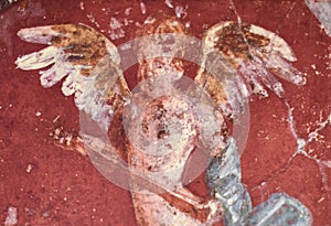 Fresco winged cupidon on red background in a Domus of the ancient Pompeii
