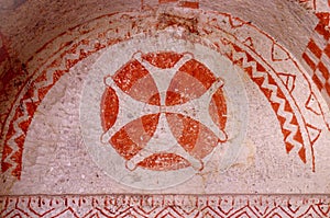 Frescos in ancient cave church painted in red directly onto rock photo