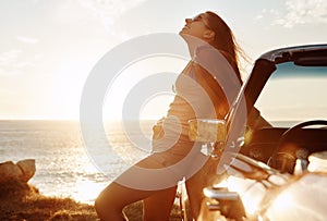 Fresh air does the soul good. a happy young woman enjoying a summers road trip.