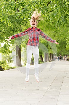 Fresh air gives her the vital energy. High energy or hyperactive kid. Small girl jumping in casual fit for energetic