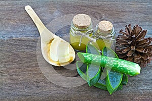 Fresh aloe vera gel on wooden spoon with aloe vera essential o photo