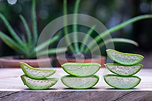 Fresh aloe vera stem slices and gel on wooden table, skin therapy concept