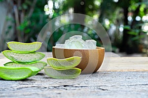 Fresh aloe vera stem slices and gel on wooden table, skin therapy concept