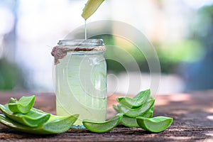 Fresh aloe vera stem slices and gel on wooden table, skin therapy concept