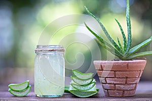 Fresh aloe vera stem slices and gel on wooden table, skin therapy concept