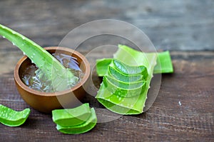 Fresh aloe vera stem slices and gel on wooden table, skin therapy concept