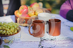 Fresh appetizing breakfast, coffee, tea and fruits on a white white lace tablecloth on a table in the street.