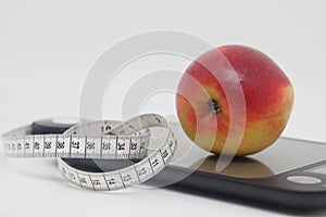 fresh apple on electronic scales and tape measure. isolated on white background. Diet concept.