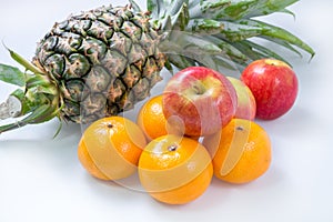 Fresh Apple Orange Pineapple on white table