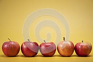 Fresh apples on a bright yellow background in an advertising foodphoto style