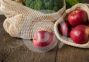 Fresh apples and broccoli in ecological reusable mesh bags made of organic cotton - zero-waste concept