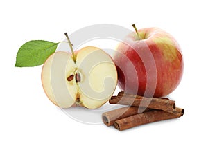 Fresh apples and cinnamon sticks on white background