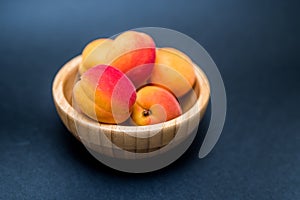 Fresh Apricots in a bowl on a dark background