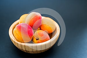 Fresh Apricots in a bowl on a dark background