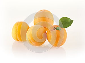 Fresh apricots with leaves on white background