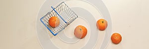 fresh arabic groupe of mandarin fruits in metal shopping basket isolated on pink background.