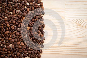 Fresh aromatic coffee beans sprinkled on a board. Coffee background.