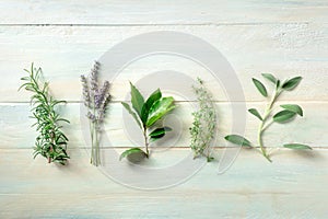 Fresh aromatic herbs, overhead flat lay shot on a wooden background