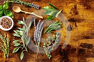 Fresh aromatic herbs, shot from above on a rustic wooden background