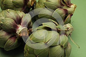 Fresh artichoke on green background. Whole green artichokes mockup. Close-up.