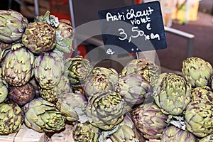 Fresh artichokes at farmers market. Local produce stack or pile for sale at the farmers market