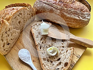 fresh artisan bread, sourdough bread, crusty bread, slices of bread, buttered slices of bread, coarse salt