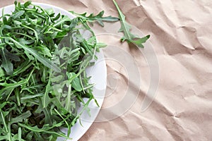 Fresh arugula Eruca, a cruciferous plant, and simply cabbage Brassicaceae on brown wrapping kraft paper.