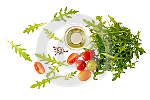 Fresh arugula salad with cherry tomatoes, olive oil bowl and spices flying