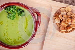 Fresh asparagus creamy soup and ingredients on a wooden table.