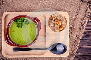 Fresh asparagus creamy soup and ingredients on a wooden table.