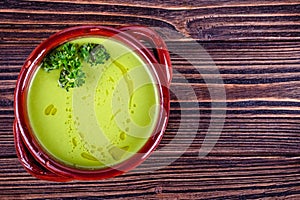 Fresh asparagus creamy soup and ingredients on a wooden table.