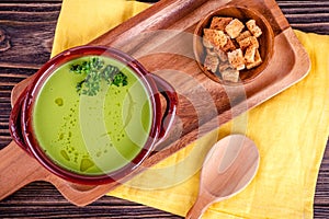 Fresh asparagus creamy soup and ingredients on a wooden table.