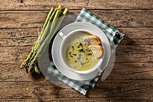 Fresh asparagus soup on wooden table