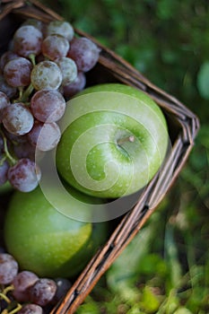 fresh assorted fruits in a wooden box, apples, grapes, close-up